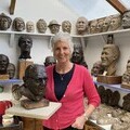 • Penny Lally with the her bust of Captain Sir Tom Moore, watched over by many of the other faces she’s captured in clay.