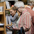 People Browsing At Cards For Good Causes Charity Shop