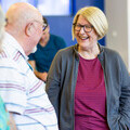 Older woman smiling while chatting to man