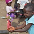 Child at a preschool washing their hands with a pump installed and maintained by Pump Aid