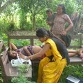 A healthcare worker performs a mobile ultrasound scan on a pregnant woman in a remote village.