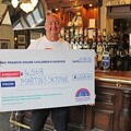 Martin Devlin, general manager of the Fletcher Moss in Didsbury with a donation of £4,568