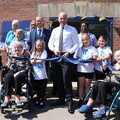 Agincare Director Adam Luckhurst cuts the ribbon at Norton Lees Care Home alongside residents Doreen (left) and Audrey, care workers & children