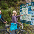 Cyclists making use of one of the new map panels at Trossachs Pier