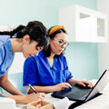 Female doctor and nurse using a laptop in a clinic