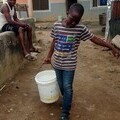 A boy  with a bucket of water