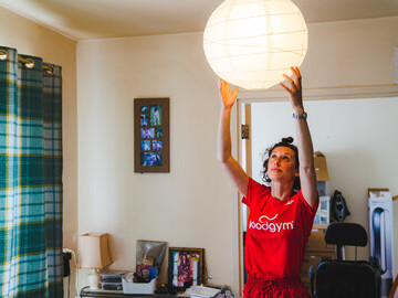 GoodGymer changing a lampshade for an older person