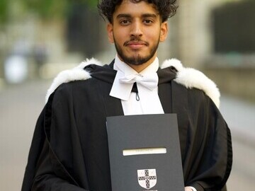 Zak Ali is holding his first class degree certificate from Cambridge