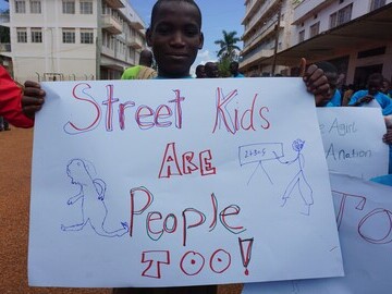 Homeless child shares sign with local community for international day for street children
