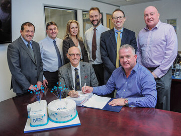 Deal for a decade! Chairman of Coastline Housing Derek Law MBE (left) and Blue Flame Director Mark Bolitho sign the 10-year contract, watched by (left