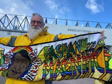 Artist David Shenton with his hand created Canaries banner outside Carrow Road Norwich. The banner will be on display at Norfolk Makers Festival