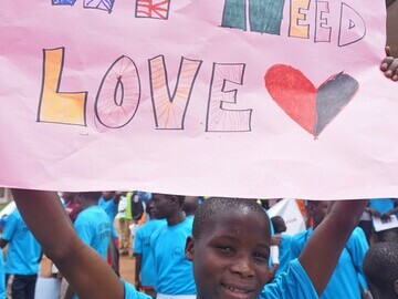 Homeless child shares sign with local community for international day for street children 2