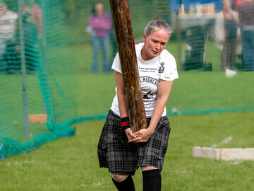 Adaptive athlete tossing the caber at Stirling Highland Games 2023