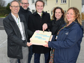 Cutting a celebratory cake to mark the 5000th home for Coastline.