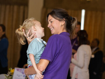 A Jessie May nurse enjoys a fun moment with a Jessie May child. 