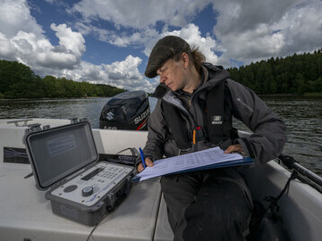 Linnéa Jägrud uses a hydrophone to monitor the movement of the first fish released into the Göta River.