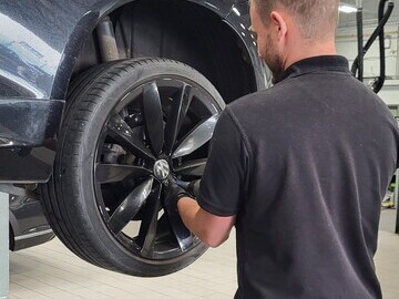 Technician checking car tyres