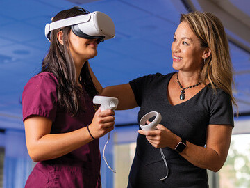 University of Minnesota BSN student Maura Talwalkar practices using an Oculus Quest 2 headset with Cynthia Bradley.
