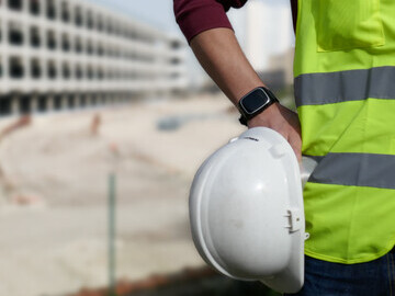 Worker in high vis wearing safety watch