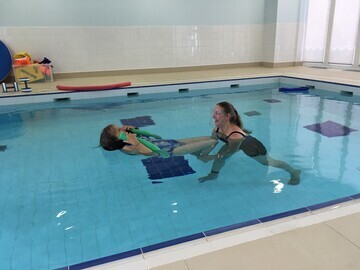 Physiotherapist in the pool with their client.