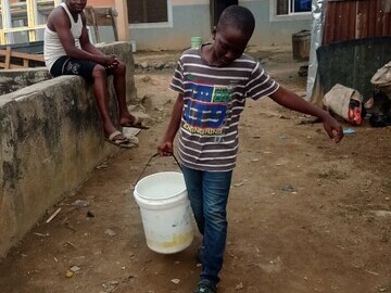 A boy  with a bucket of water