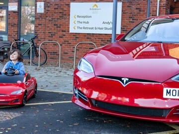 Orion (four) test drives the new RadioFlyer Tesla car outside St Andrew