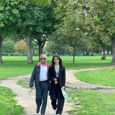 A VIP walks with a young Travel Hands volunteer in the park, sharing smiles and a peaceful stroll—showcasing support, inclusion, and companionship.