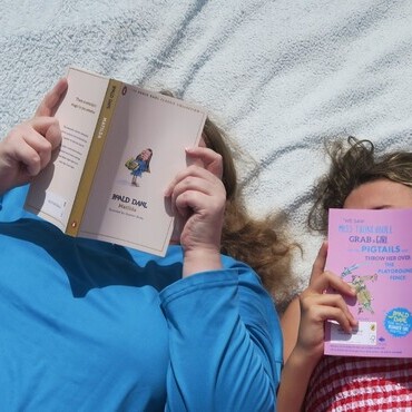 Adult And Child Reading The Same Book